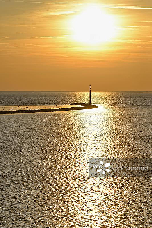 瓦登海日落，石质防波堤与航标，德国下萨克森图片素材