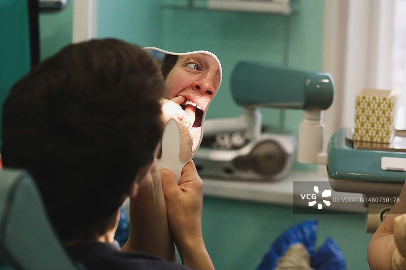 正畸医生在牙科修复体上工作，女患者试戴并照镜子图片素材