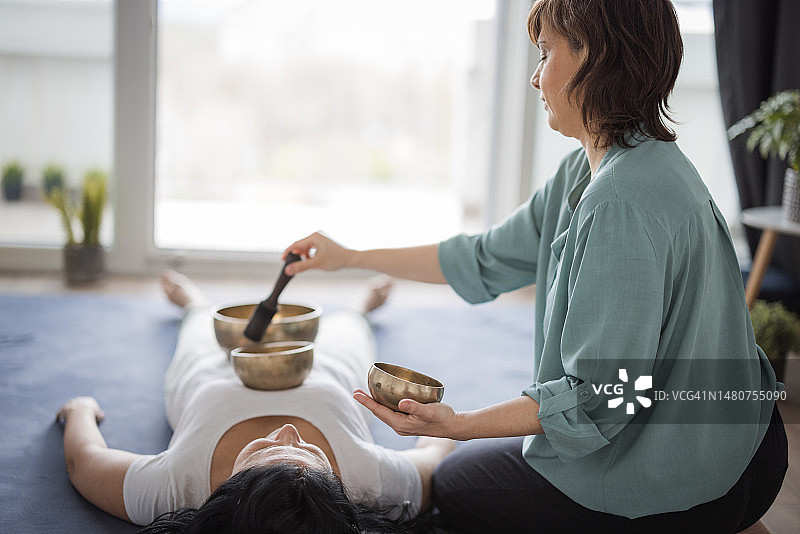 按摩师为顾客进行藏族颂钵按摩图片素材