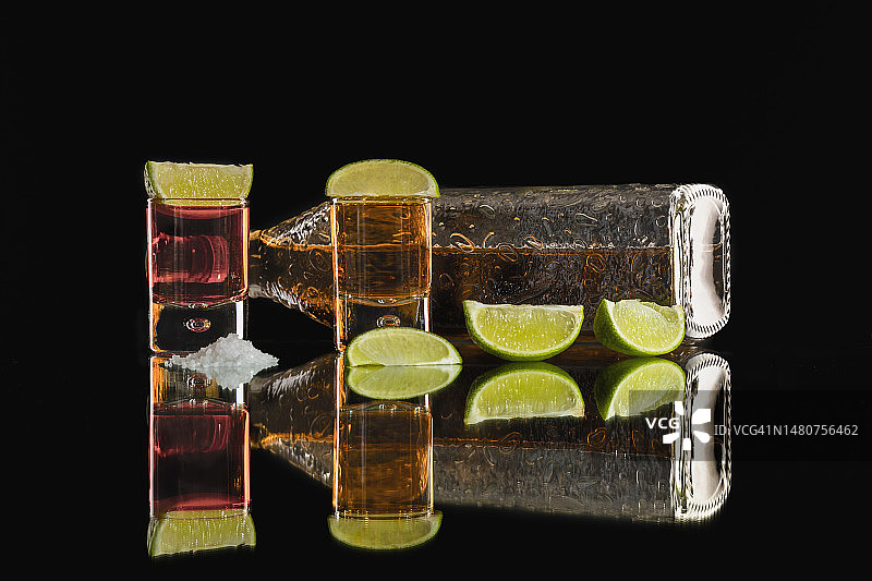 两杯龙舌兰酒，配柠檬和一瓶酒图片素材