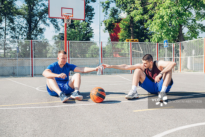 坐在球场上聊天的篮球运动员图片素材