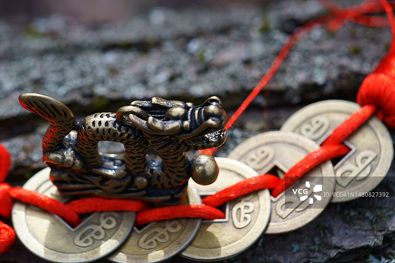中国古币旁的龙雕像特写图片素材