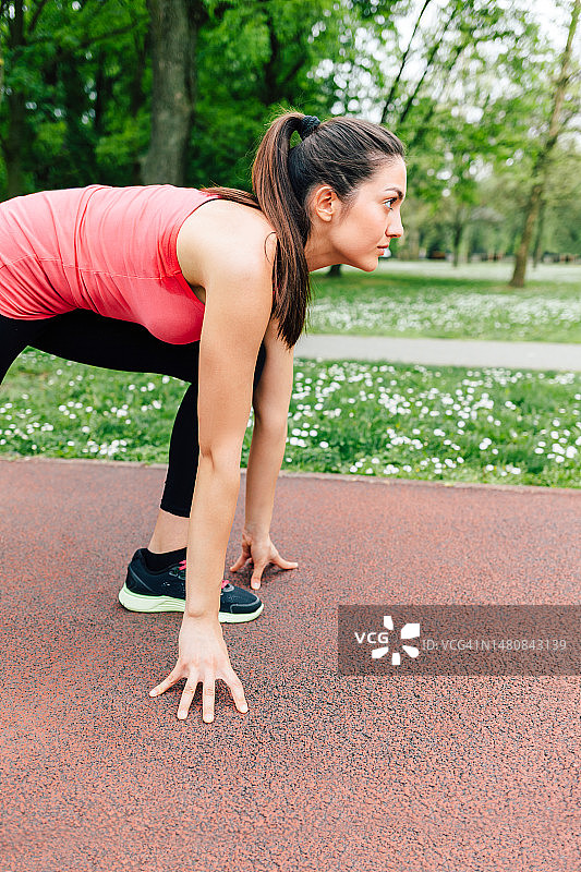 年轻女人准备在跑道上跑步图片素材