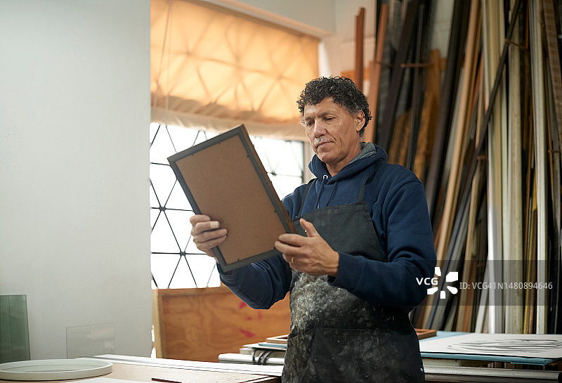 相框，建筑工人和男人正在做一个房子的绘画翻新。老年男性，室内设计和艺术的老人工作相框的房间维修图片素材