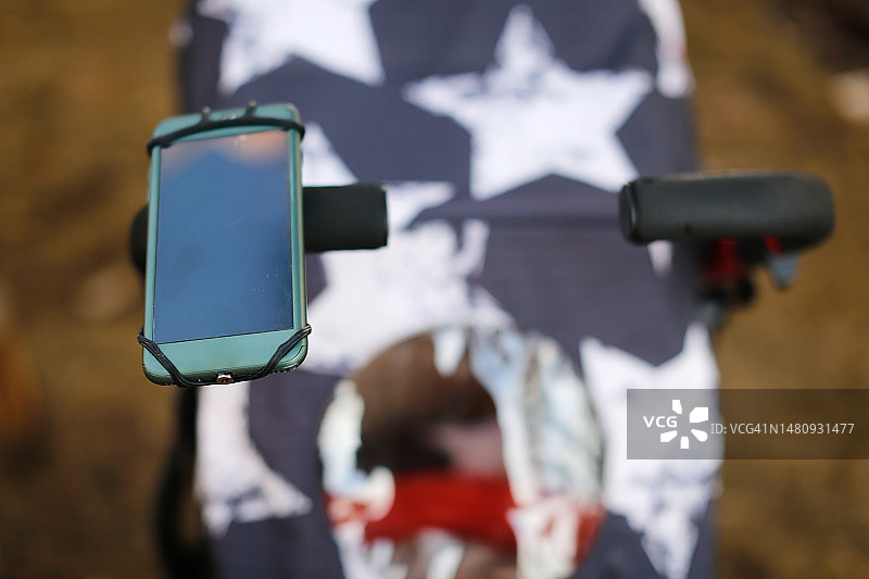 安装在婴儿车上的智能手机。智能手机屏幕的特写图片素材