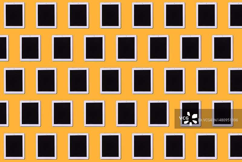 黄色背景上的白色平板电脑图案：智能设备概念图片素材