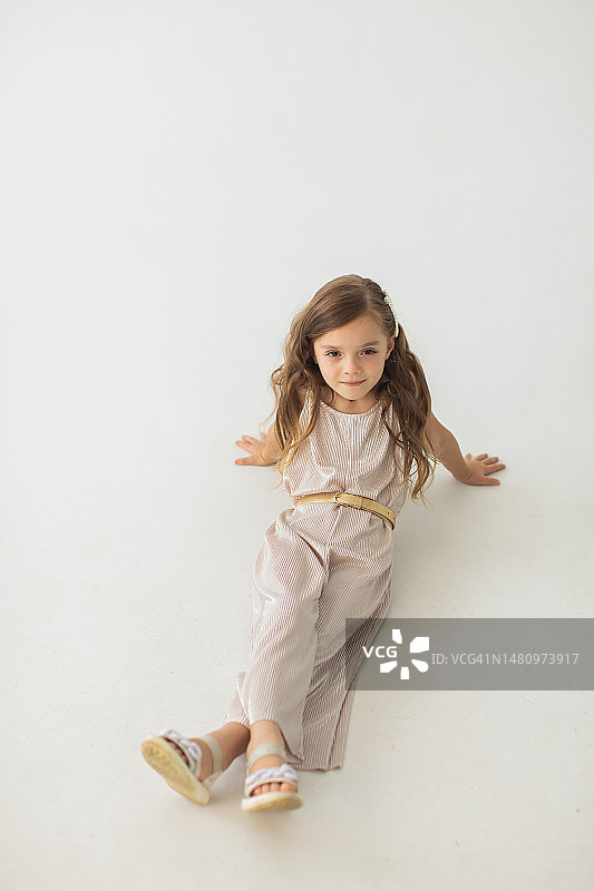 在白色背景工作室里身穿银色连衣裙的金发女孩图片素材