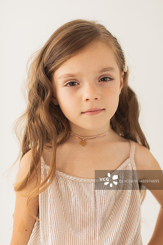 在白色背景工作室里身穿银色连衣裙的金发女孩图片素材