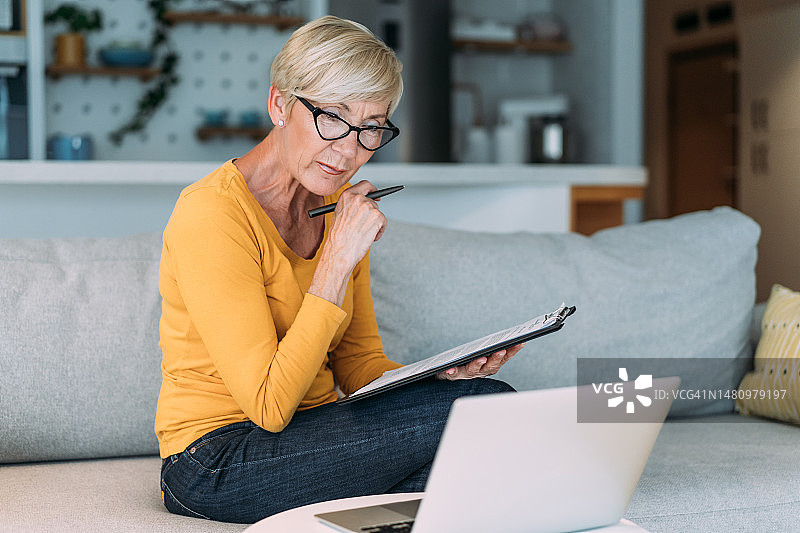 管理预算、支付账单和税收的老年女性。图片素材