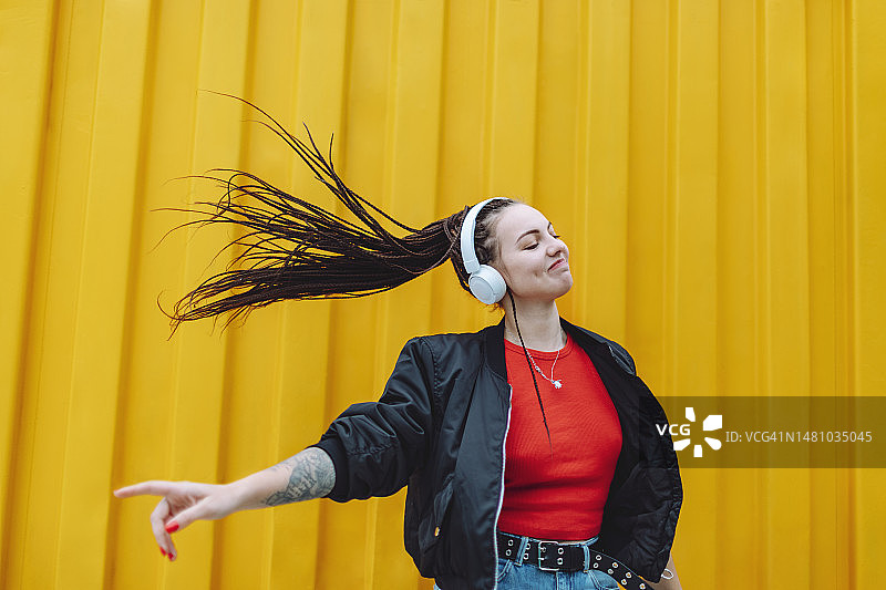 年轻女子用手机和耳机听音乐跳舞图片素材