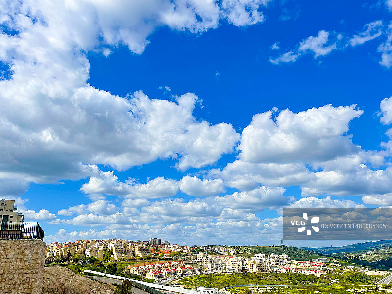 拉马特贝特谢梅什山坡上房屋上方的蓬松云朵图片素材