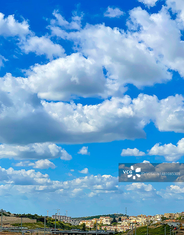 拉马特贝特谢梅什山坡上房屋上方的蓬松云朵图片素材