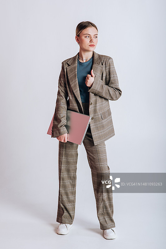 身穿职业装的金发女人在白色背景上使用笔记本电脑图片素材