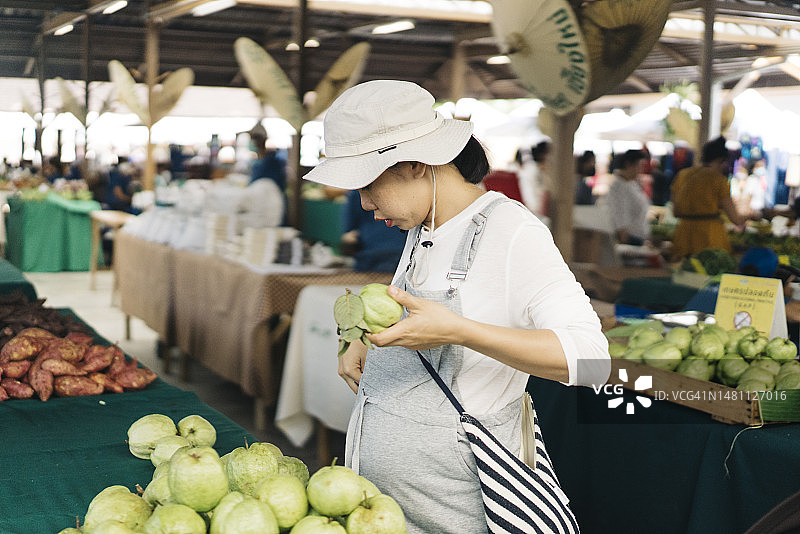 亚洲孕妇在有机蔬果市场购买水果图片素材