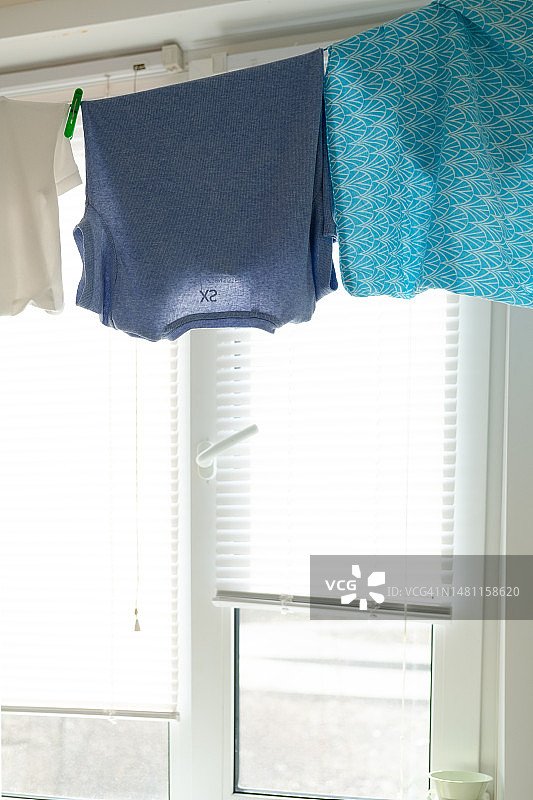 厨房里晾晒的湿衣服，百叶窗背景图片素材