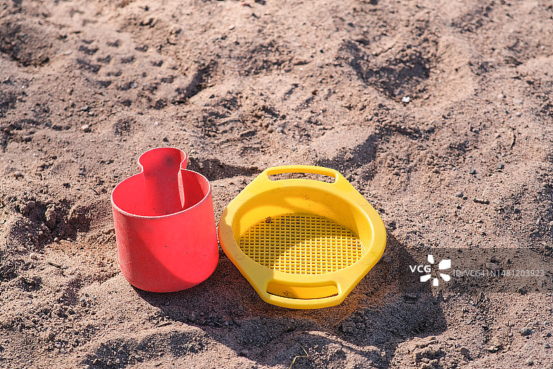 沙盒里的黄红色塑料玩具图片素材