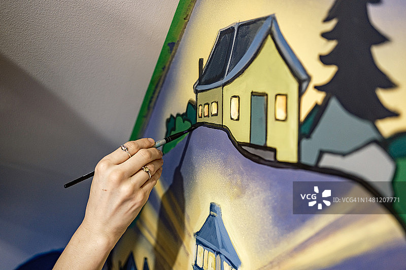 年轻女艺术家在阁楼绘制壁画的手部特写图片素材
