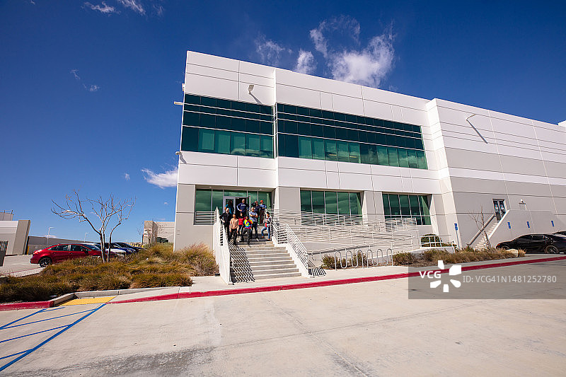 白天站在配送中心外的不同人群的长镜头图片素材