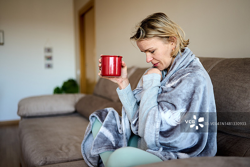 盖着毯子的年轻抑郁女性图片素材