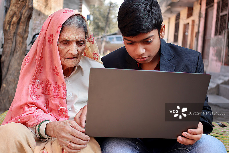 孙子和奶奶一起使用笔记本电脑图片素材