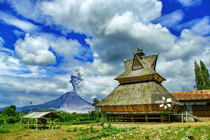 西纳邦火山在白天喷发，前景是卡罗传统房屋图片素材