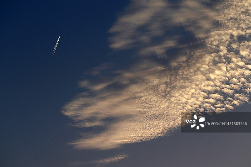 印度蓝天下的卷积云和飞机尾迹图片素材