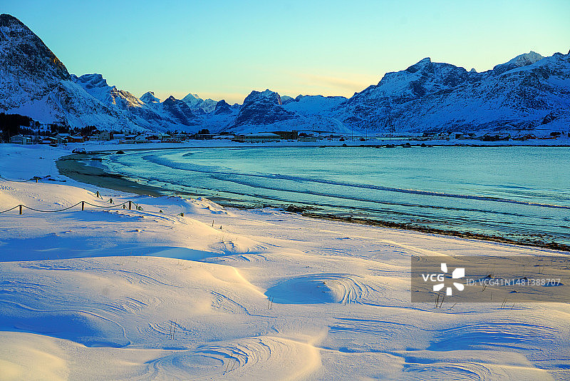 挪威罗弗敦群岛弗拉克斯塔岛兰伯格斯特兰达海滩的雪景日落光图片素材