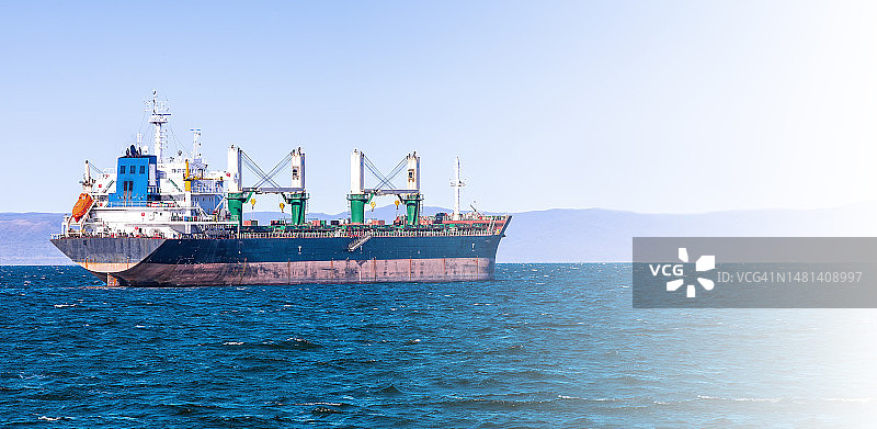 沐浴在柔和阳光下的符拉迪沃斯托克港散货船图片素材