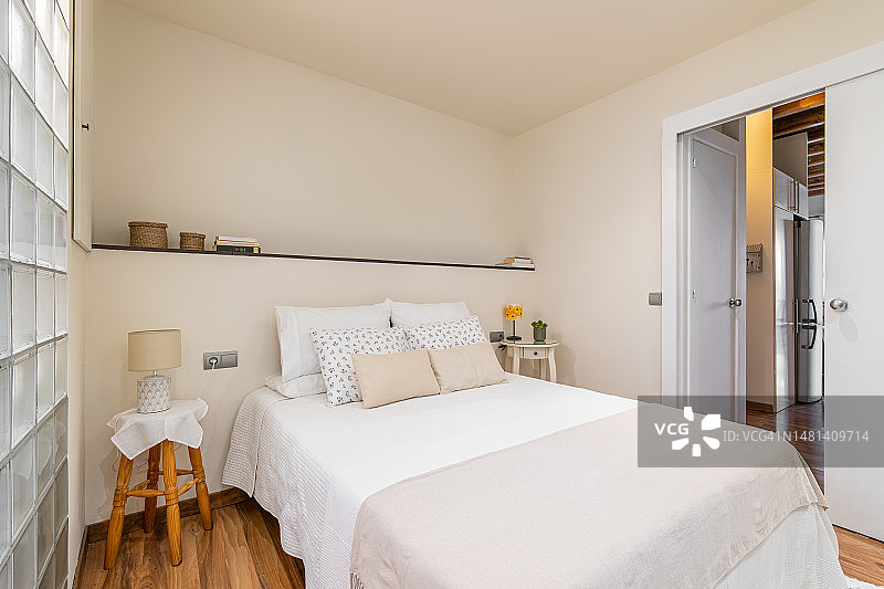 带双人床、桌子、搁板的小卧室的极简主义设计图片素材