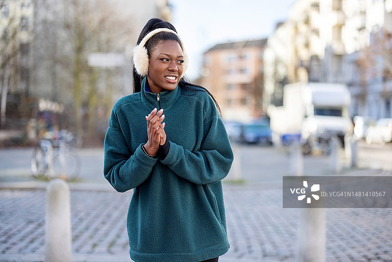在城市户外晨跑后感到寒冷的年轻非洲女人图片素材