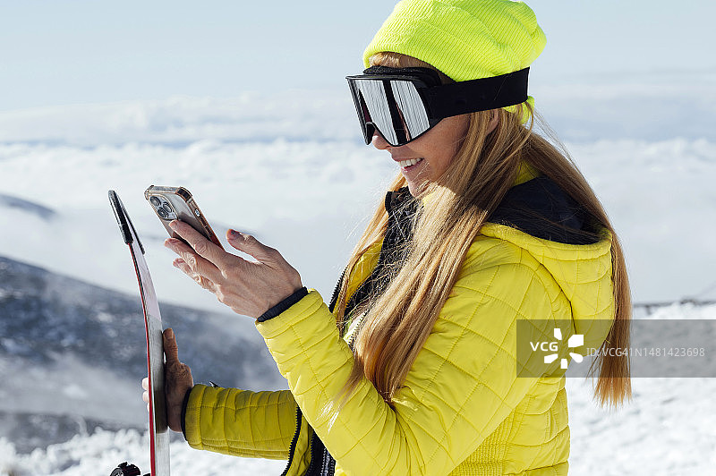 女人滑雪时看着手机图片素材