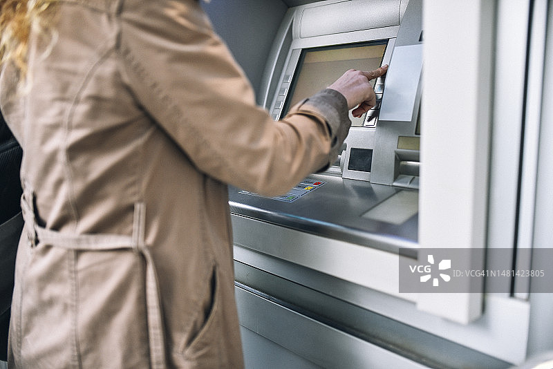 女人按密码键，拿着钱包图片素材