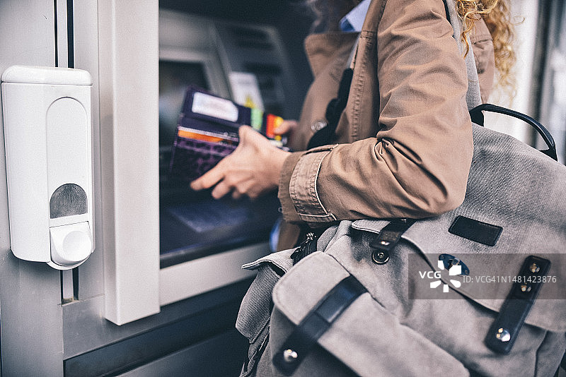 女人按密码键，拿着钱包图片素材