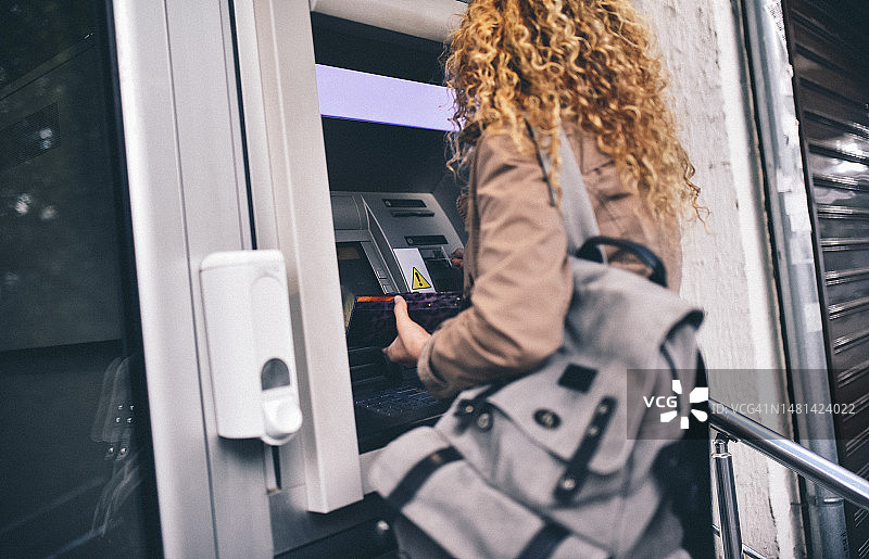 年轻女人在ATM机前图片素材