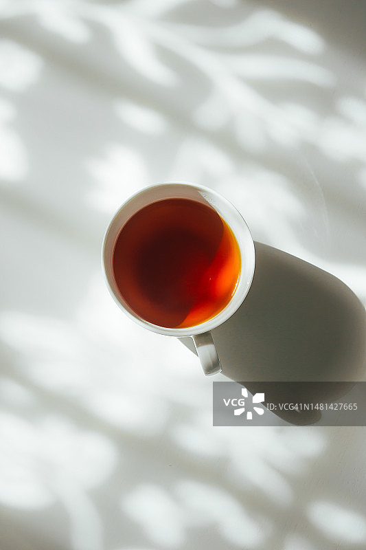 白色茶杯与自然窗帘阴影背景（哈萨克斯坦）图片素材