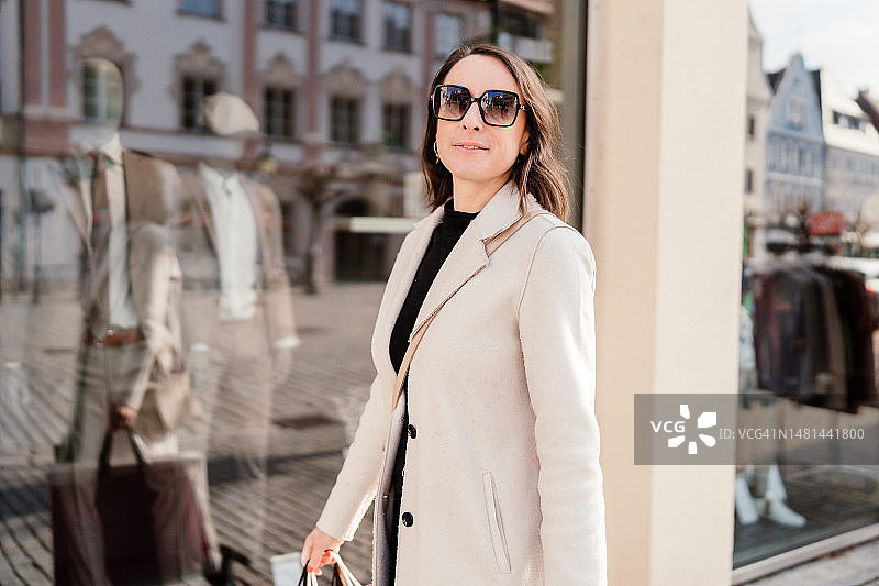 在城市里拎着购物袋行走的女人图片素材