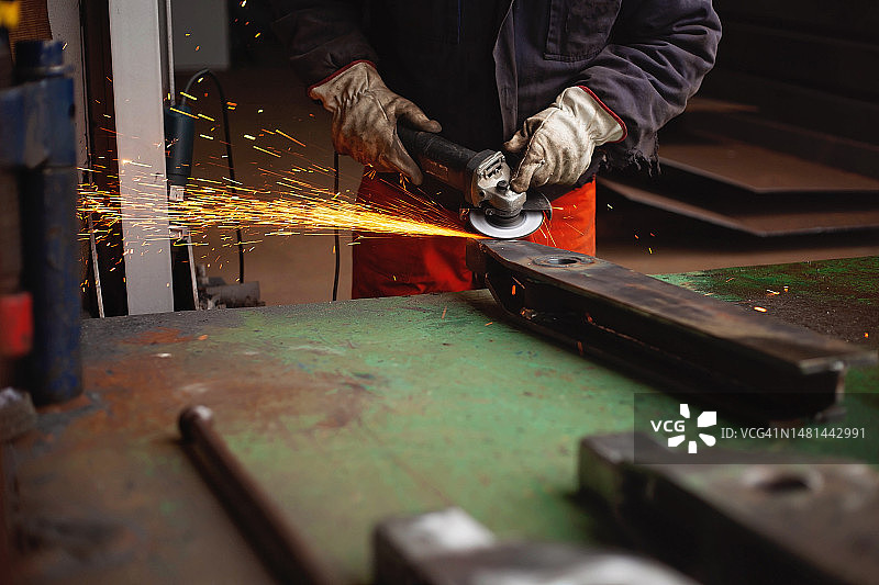 在金属加工厂清洁金属零件的工人图片素材