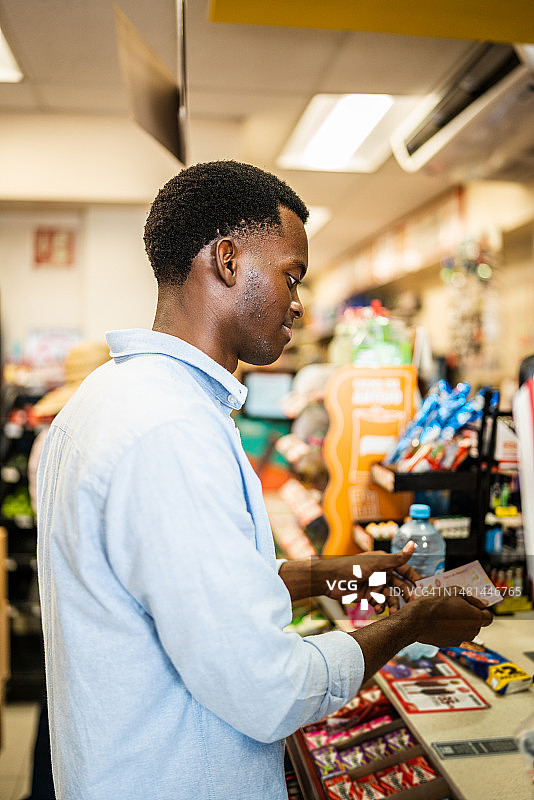 年轻男子在零售店付款图片素材