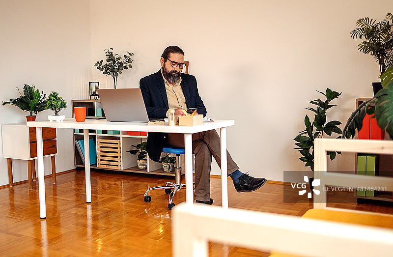 在办公室手持智能手机的商人图片素材