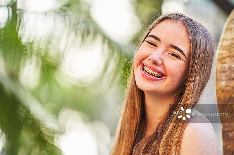 有皮肤问题和牙套的青少年对着镜头微笑图片素材