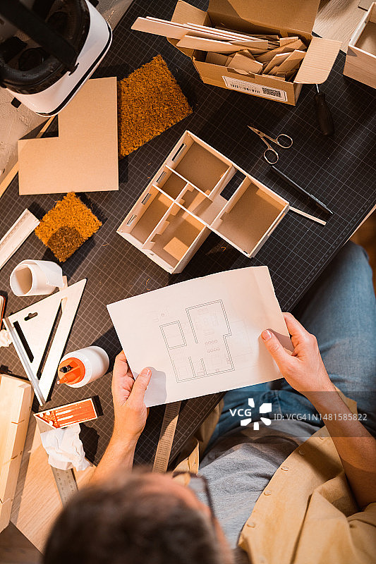 建筑师将建筑模型与蓝图进行比较图片素材