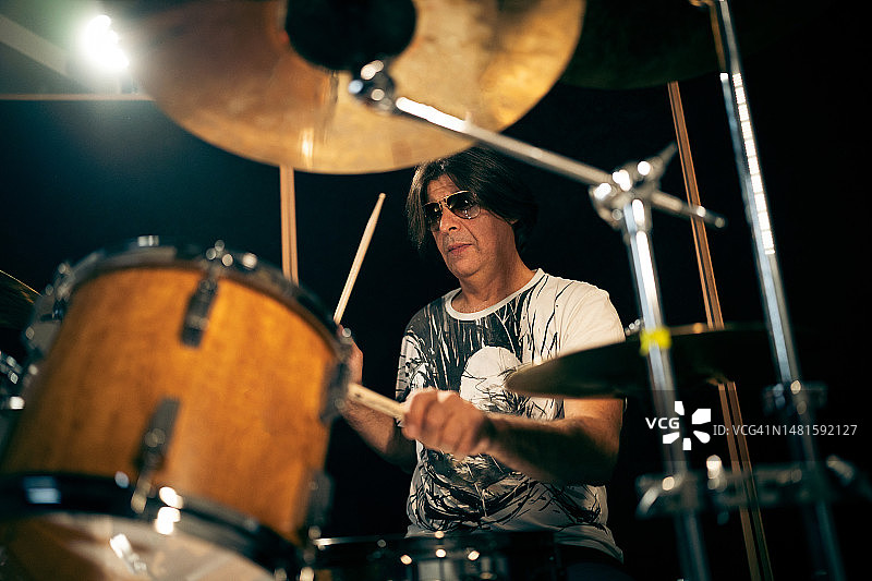 在中录音室演奏鼓的中年男子音乐家图片素材