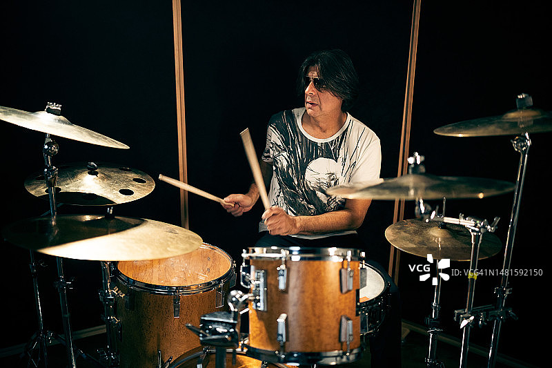 在中录音室演奏鼓的中年男子音乐家图片素材