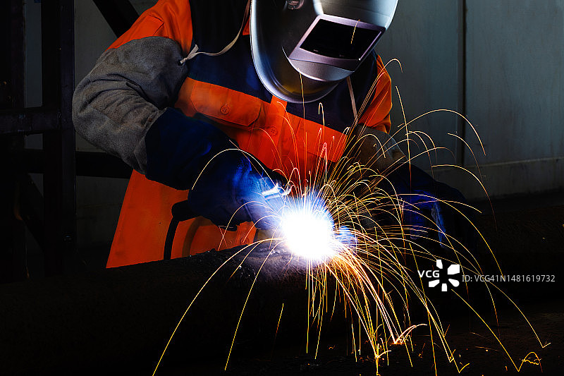 建筑工地中焊接管道的专业焊工图片素材