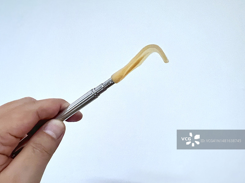 成年人的手拿着一个可伸缩的挠痒工具图片素材