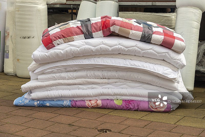 室外堆放的各种颜色的羽绒被图片素材