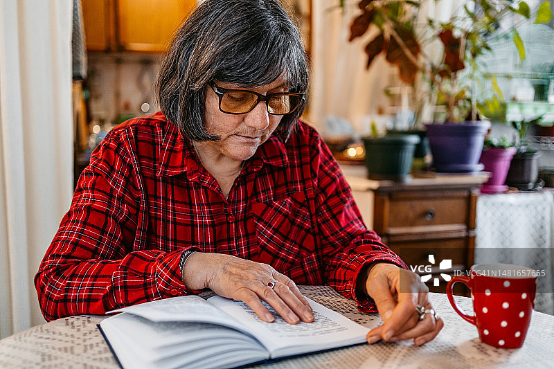 年长的女人在家读书图片素材