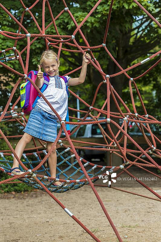 德国基尔：带书包的7岁女孩在秋千上玩耍图片素材