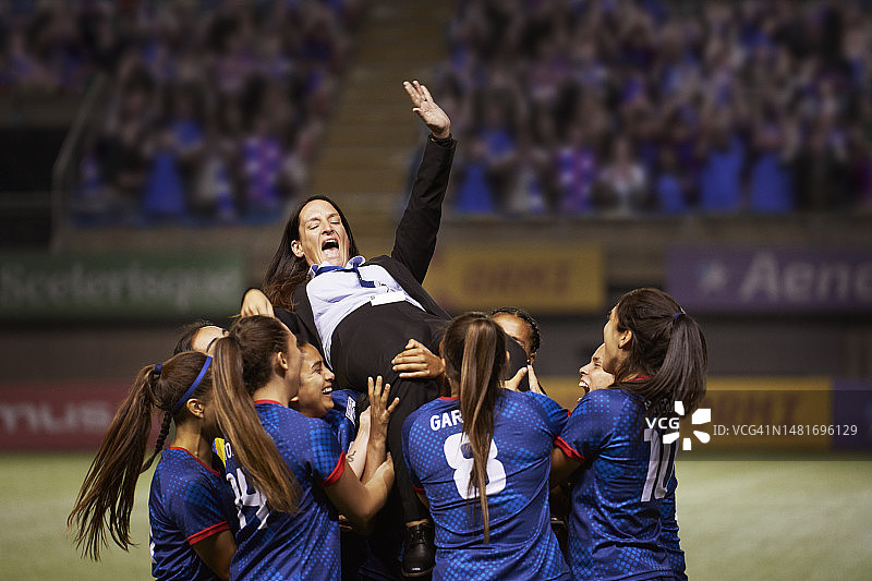 足球队员们把教练高高举起，庆祝赢得冠军图片素材