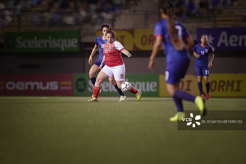 运动型中场足球运动员在比赛中接进攻传球图片素材